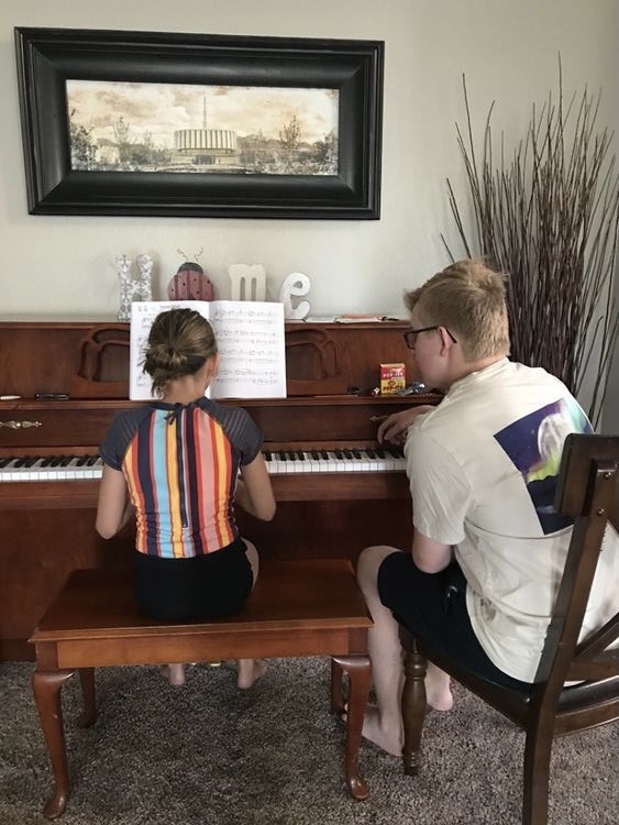 Michael Dustin teaches younger kids how to play the piano.