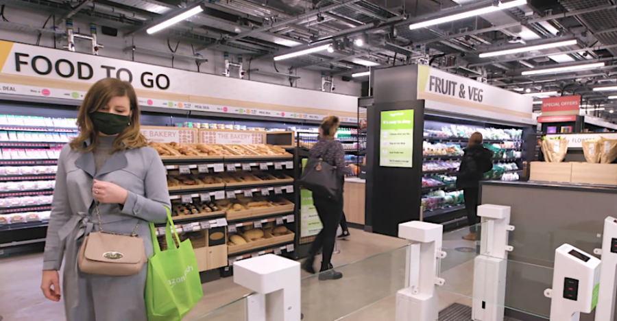 This is an image of the inside of the Amazon Fresh store with people shopping. 