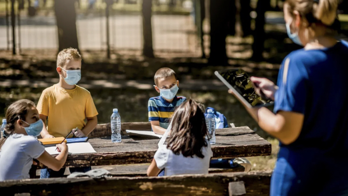 Campers wearing masks at a picnic table 