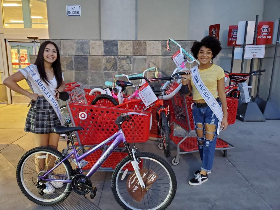 Aiyanna Castro (left) and Bella Hawkins (right) show their shopping cart full of donations.