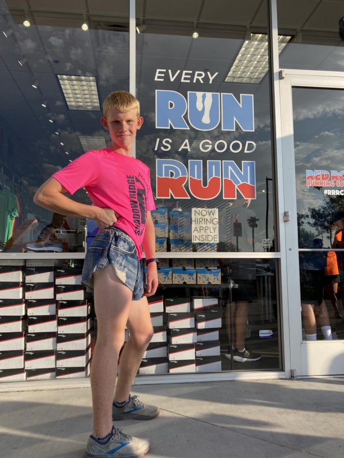 Hughes shows off his cross country jorts outside Red Rock Running Company (Photo By: Kale Nelson)
