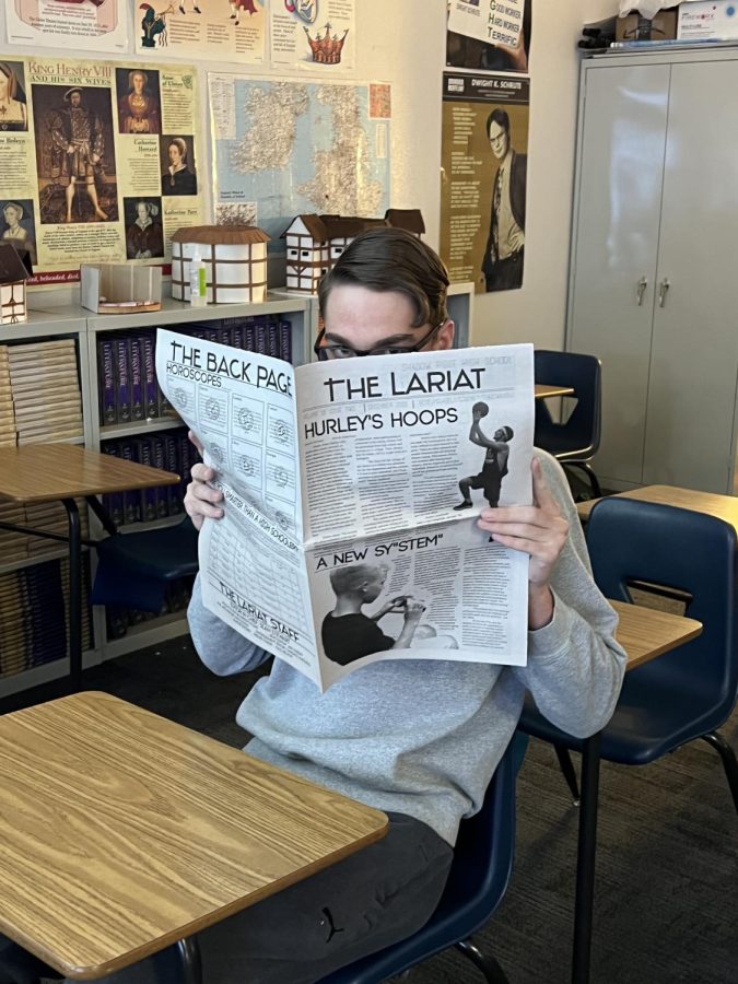 Senior, Kale Nelson, cherishing a print copy of The Lariat.