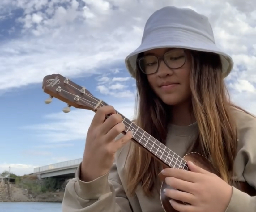 Soriya Ritchie playing the Ukulele in a bucket hat