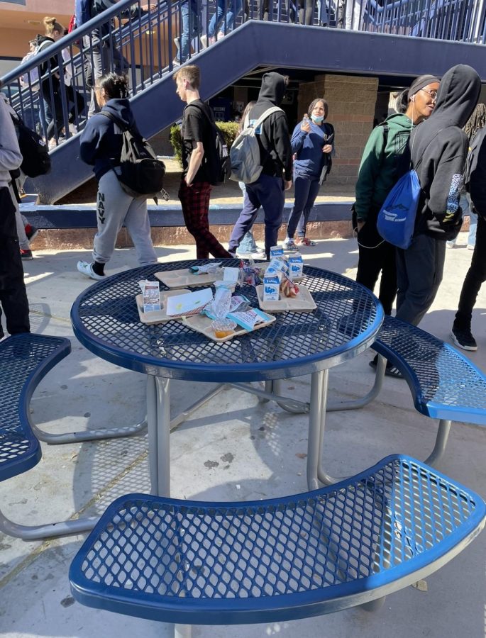 Trash on a lunch table in the quad