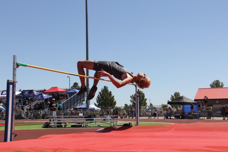 A student-athlete high jumping at an invitational meet!