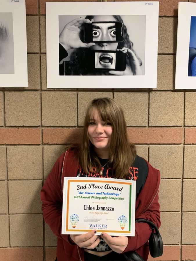 Chloe Jannazzo showing off their artwork and award. 