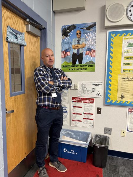 Bedingfield posing next to a poster his student made for him.