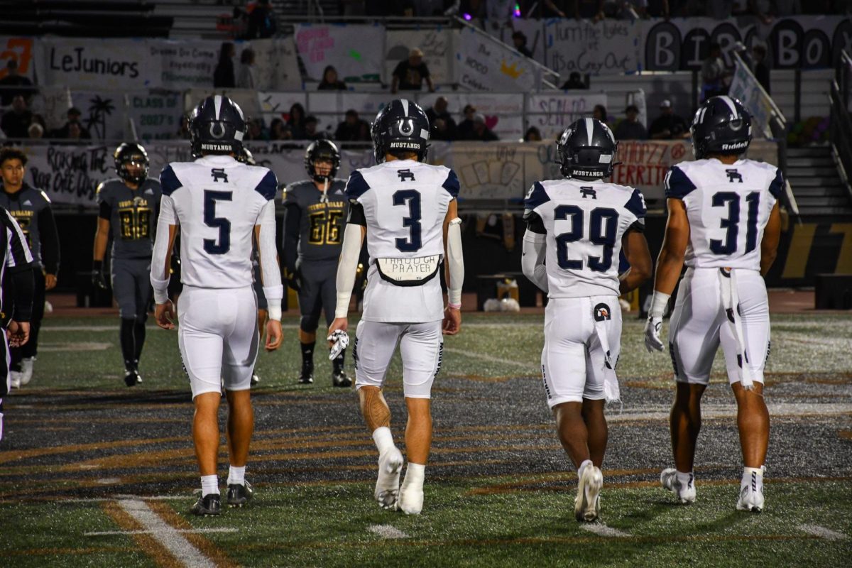 Team captains meet opposing teams captains for coin toss.