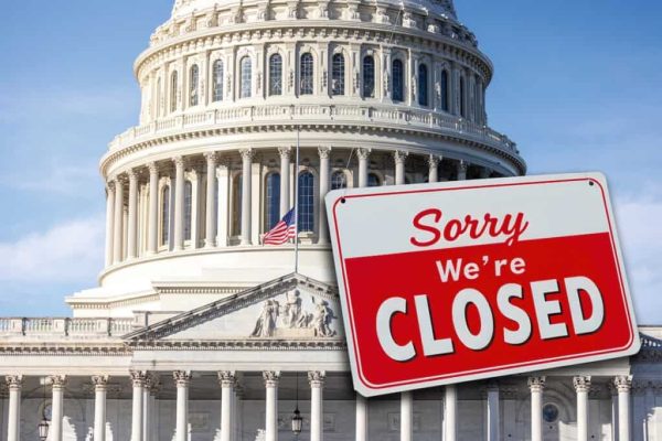 The US Capitol  with a closed sign hanging from the dome. The concept explores the federal government shutdown as a result of Congress not being able to pass a budget.