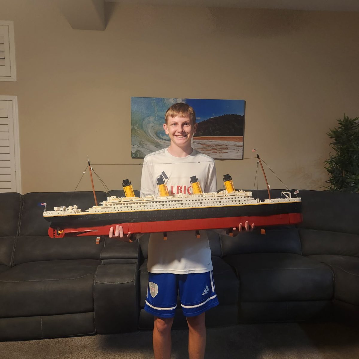 Brandon Barret standing with one of his LEGOS after he had completed building it.