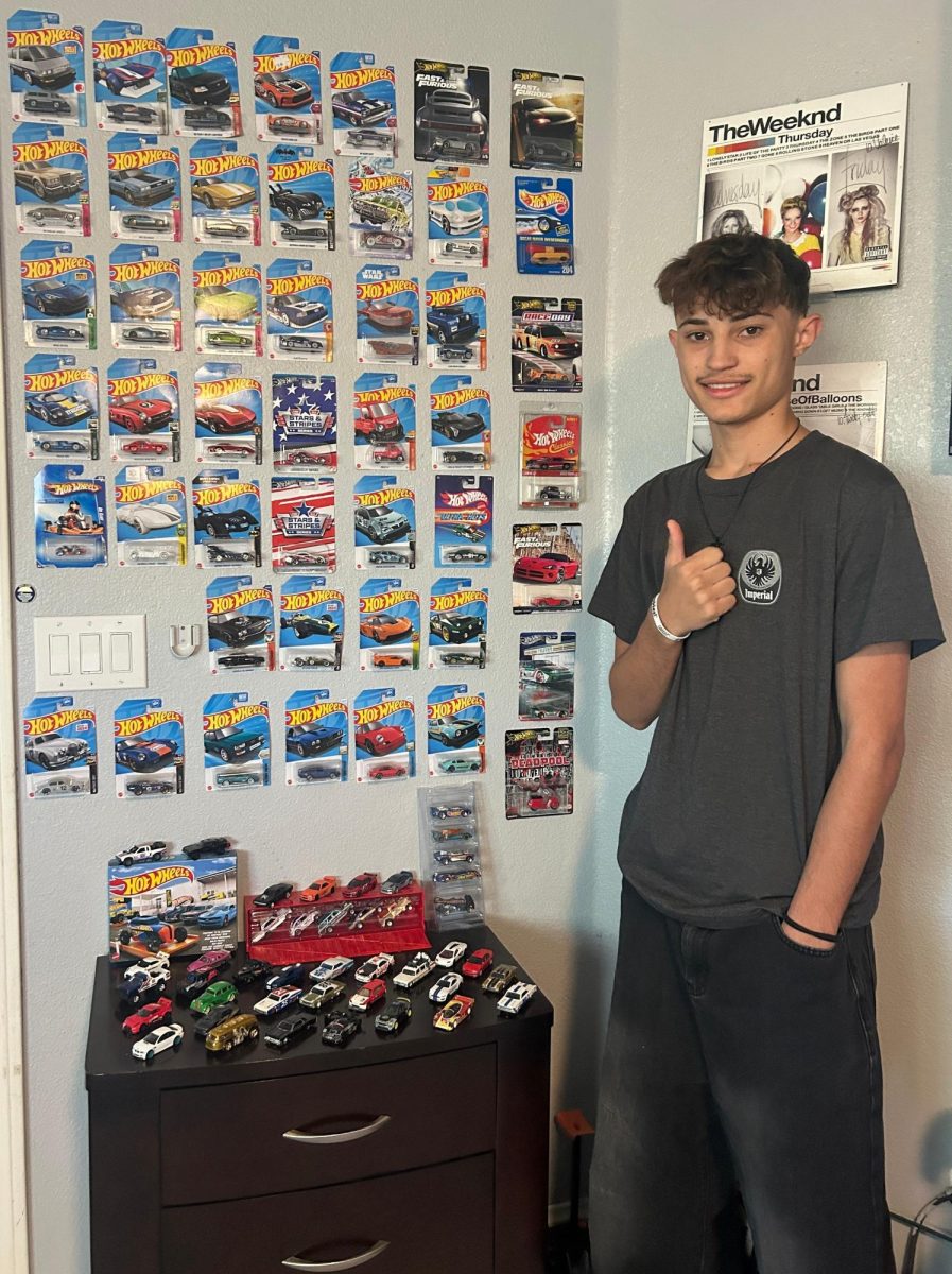 Kyle Bean standing proud by his wall of cars.