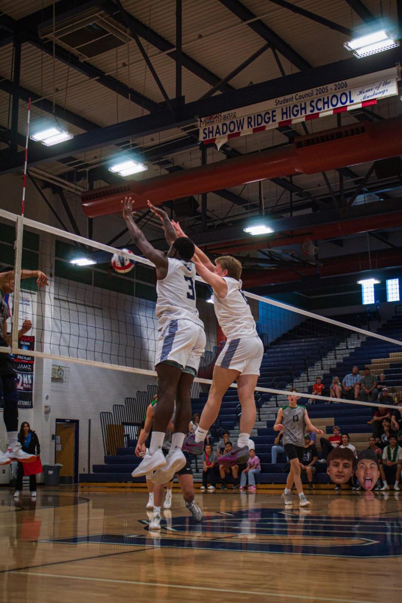 Max jumping up for a block with his teammate Zion.