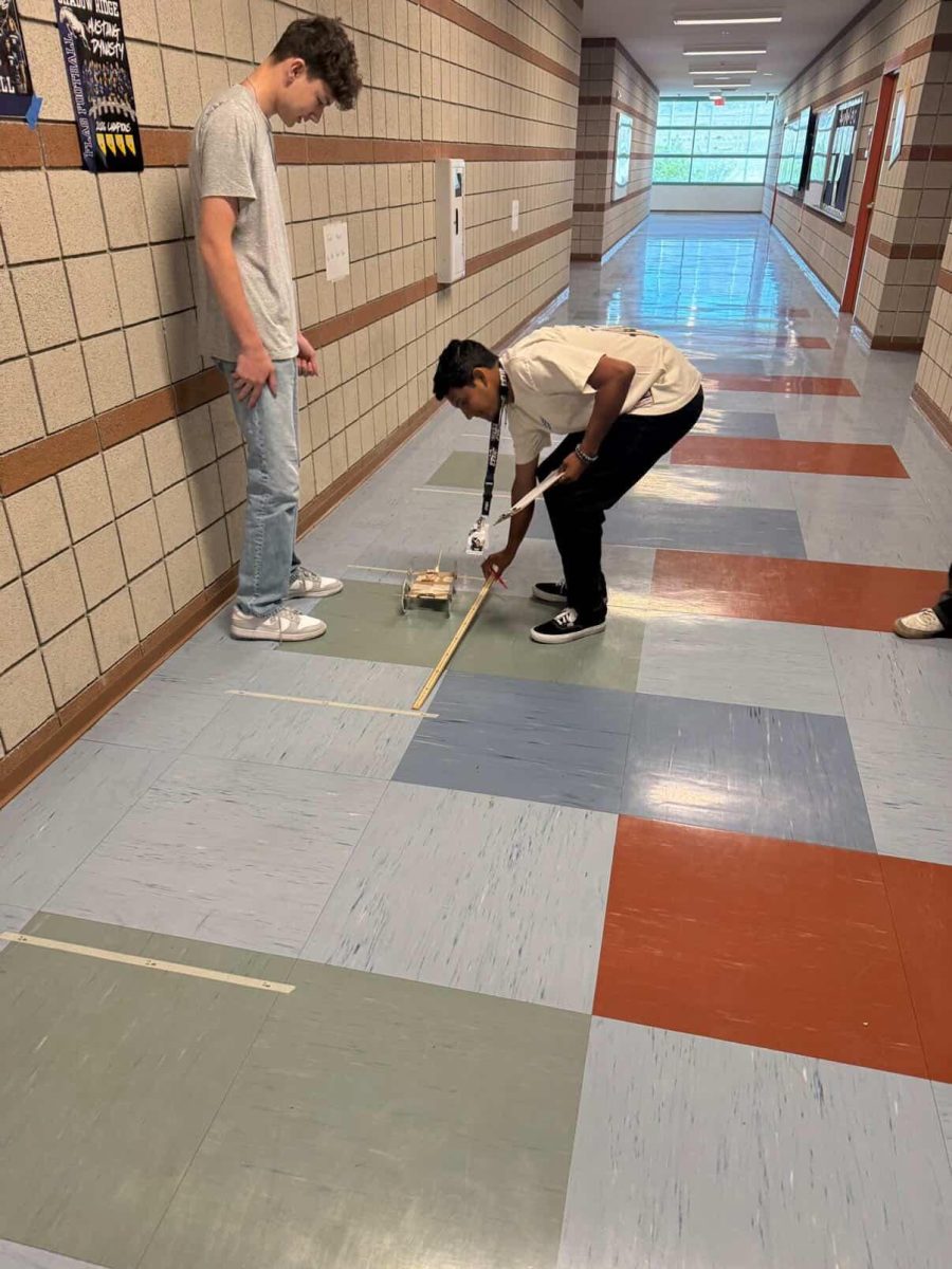 Mr. Payne helps student measure out distance.